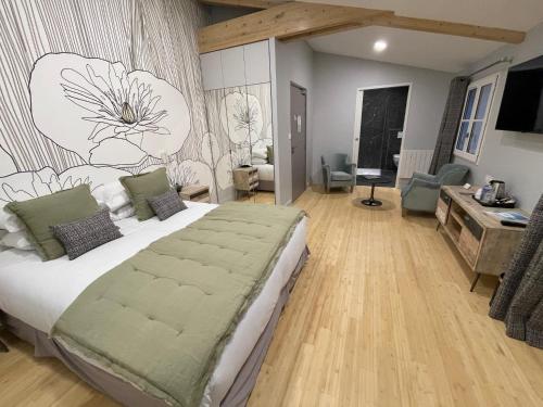 a bedroom with a large bed with a flower mural on the wall at Le Clos Du GALION - Ile de Ré in Saint-Martin-de-Ré