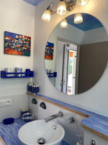 une salle de bain avec un lavabo et un miroir dans l'établissement L'oasis des Tamaris, à Les Sables Vignier