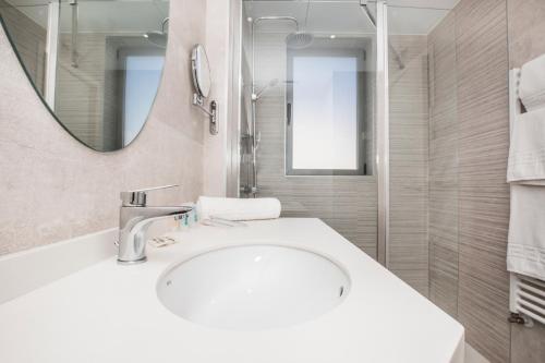 a bathroom with a sink and a mirror at Hotel Ciudad De Ávila in Avila