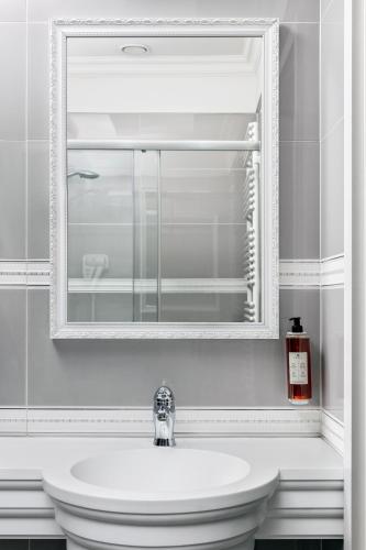 a bathroom with a white sink and a mirror at Merci Boutique Hotel in Krakow