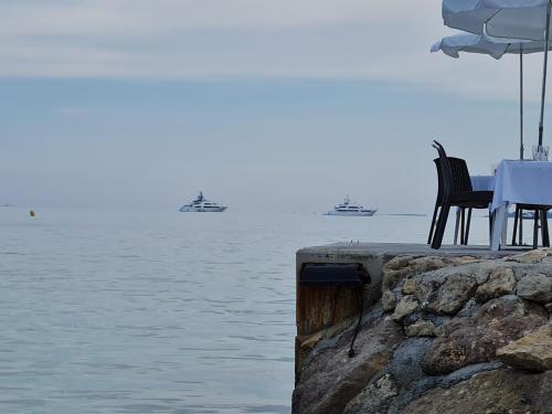a table and chairs sitting next to the water at Appartement T2 bord de mer climatisé in Juan-les-Pins