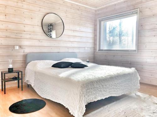 a bedroom with a white bed and a mirror at Villa Avara Ellivuori Finland in Sastamala