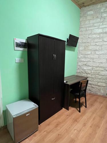 a black cabinet and a table in a room at Zouglas App Guesthouse in Limassol