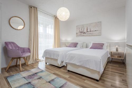 een witte slaapkamer met een groot bed en een paarse stoel bij Luxury Apartments Gina in Rovinj