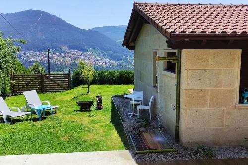 a house with chairs and tables in a yard at Casa nueva en Vigo Rural Mos con Jacuzzi y chimenea in Pontevedra