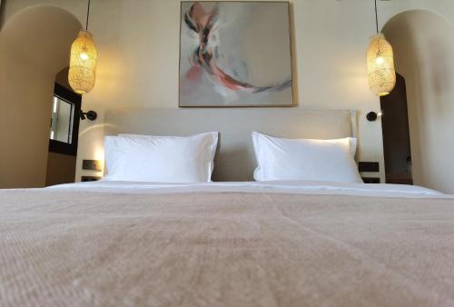 a bedroom with a large bed with two white pillows at NOS Hotel & Villas in Sifnos