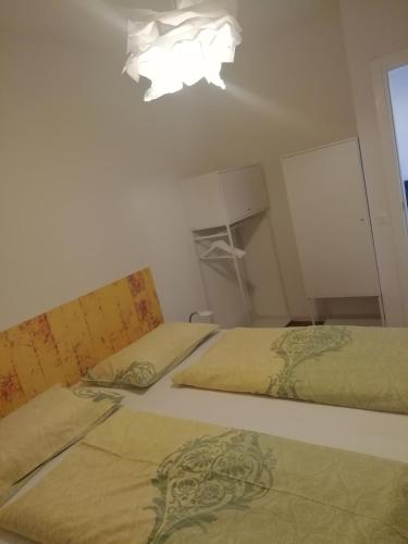 2 camas en un dormitorio con lámpara de araña en Appartamento Gardolo en Trento