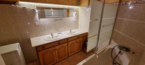 łazienka z 2 umywalkami, prysznicem i wanną w obiekcie Lou Francese w mieście Ceillac