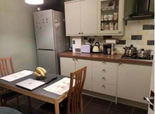 uma cozinha com uma mesa e um frigorífico em Cheerful Heeley Home em Heeley