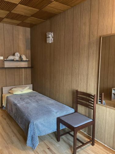 1 dormitorio con 1 cama y 1 silla en Helge Guest Apartment, en Valga
