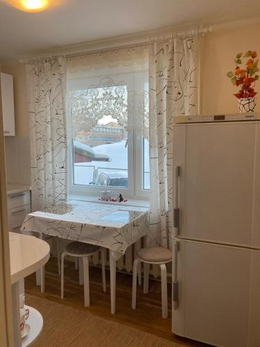 uma cozinha com uma mesa, uma janela e um frigorífico em Helge Guest Apartment em Valga