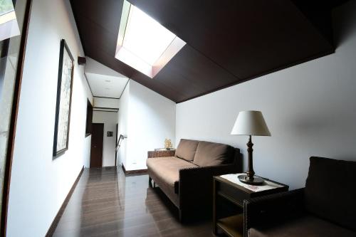 a living room with a couch and a skylight at 高野山 宿坊 普門院 -Koyasan Shukubo Fumonin- in Koyasan