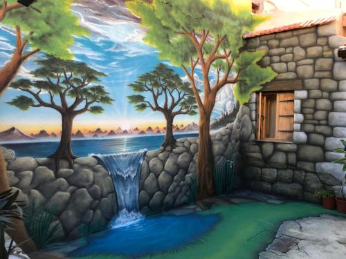 a wall with a painting of trees and a waterfall at Zouglas App Guesthouse in Limassol