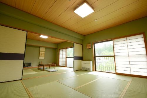 an empty room with green walls and windows at 高野山 宿坊 普門院 -Koyasan Shukubo Fumonin- in Koyasan