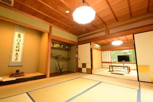 a japanese room with a television and a table at 高野山 宿坊 普門院 -Koyasan Shukubo Fumonin- in Koyasan