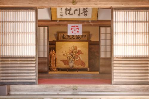 an entrance to a building with a painting on the wall at 高野山 宿坊 普門院 -Koyasan Shukubo Fumonin- in Koyasan