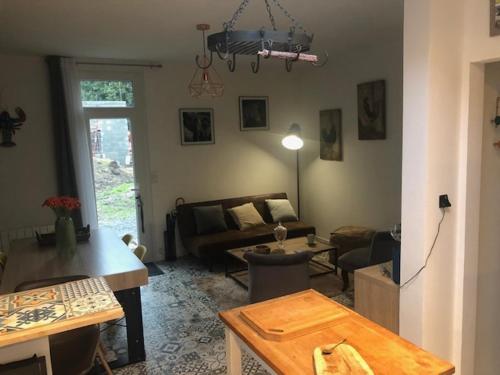 ein Wohnzimmer mit einem Sofa und einem Tisch in der Unterkunft Dinard-jolie maison au calme proche plage in Dinard
