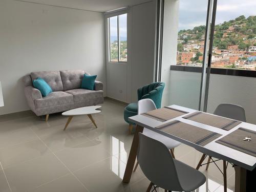 ein Wohnzimmer mit einem Sofa, einem Tisch und Stühlen in der Unterkunft Bello Apartamento , Ubicado en el mejor sector in Cúcuta