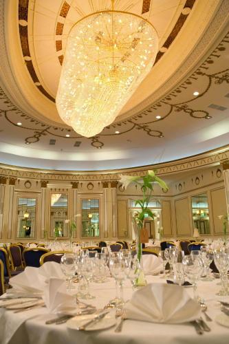 a dining room with white tables and a chandelier at The Midland Hotel in Bradford