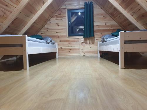 a room with two beds in a wooden cabin at Warta House - Domek z kominkiem nad Wartą in Prusicko