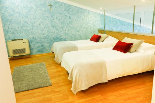 a bedroom with two beds and a blue wall at Le Onde Resort in Viterbo