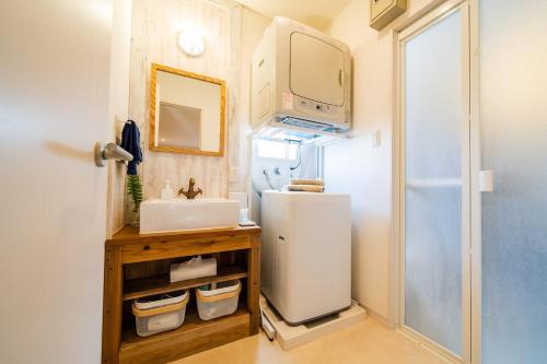 a small kitchen with a sink and a refrigerator at Guesthouse Seawall in Ginowan