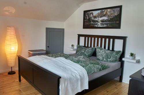 een slaapkamer met een bed met groene en witte kussens bij Green-Art-Living im Allgäu für 4 mit Queensize & WIFI in Lauben
