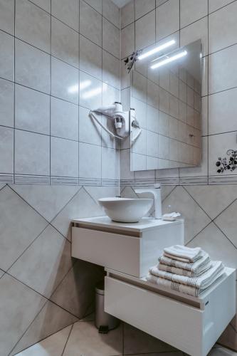 a white bathroom with a sink and a mirror at Sobe "Ela" in Fužine