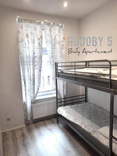 a bedroom with two bunk beds and a window at Apartament Biały CHUDOBY 5 Gliwice in Gliwice
