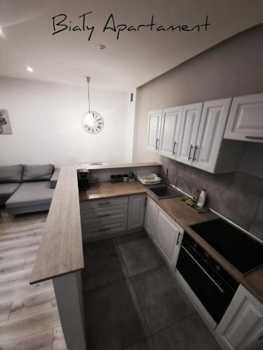 a kitchen with white cabinets and a counter top at Apartament Biały CHUDOBY 5 Gliwice in Gliwice