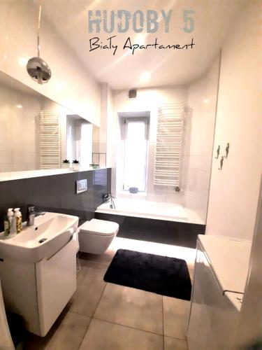 a bathroom with a toilet and a sink and a tub at Apartament Biały CHUDOBY 5 Gliwice in Gliwice