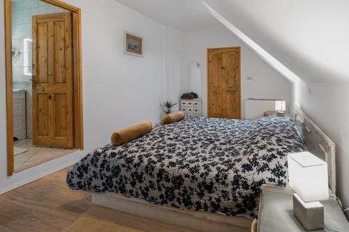a bedroom with a bed with a black and white comforter at Sobe "Ela" in Fužine