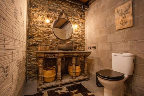 a bathroom with a sink and a toilet and a mirror at JAT MOUNTAIN HOUSES - Casa Pairal Jarca - dúplex - a 1 km de Canillo in Canillo