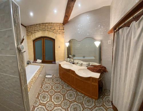 Luxury family villa in the heart of Gascony. Large pool & gorgeous view في Tourdun: حمام مع حوض وحوض ومرآة