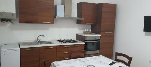 uma cozinha com um fogão, um lavatório e uma mesa em Casa Vacanze Cerreto 2 em Miglianico