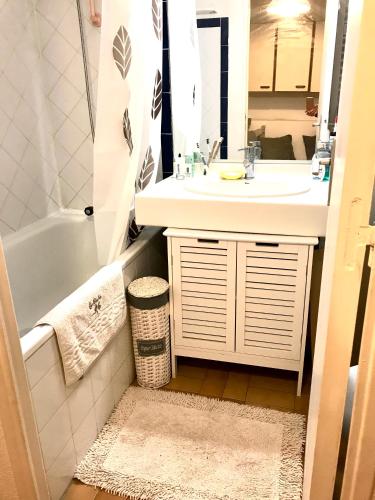 une salle de bain avec un lavabo, une baignoire et un miroir dans l'établissement Cap Sud, sea & sun, à Grimaud