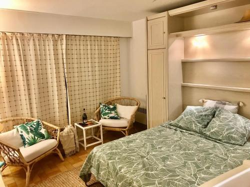 une chambre avec un lit et deux chaises dans l'établissement Cap Sud, sea & sun, à Grimaud