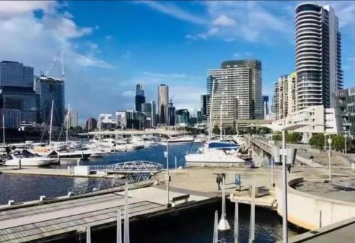 a marina in a city with boats in the water at Lovely waterfront condo with swimming pool and gym in the heart of Docklands in Melbourne