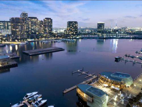 a view of a city from a harbor at night at Lovely waterfront condo with swimming pool and gym in the heart of Docklands in Melbourne