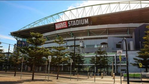 a view of a marvel stadium with trees in front at Lovely waterfront condo with swimming pool and gym in the heart of Docklands in Melbourne