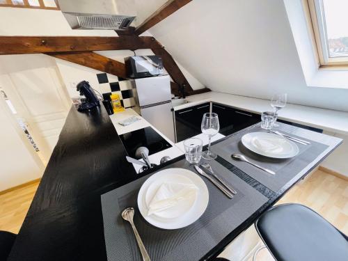 a dining table with two white plates on it at Appartement Oasis de Confort in Tourcoing