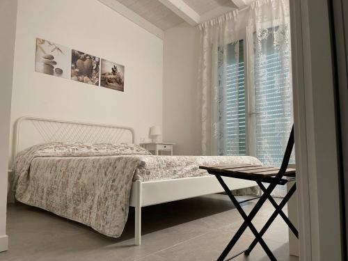 a bedroom with a bed and a chair and a window at Azzurramare Bed & Breakfast in Grottammare