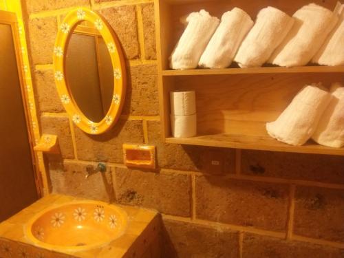 y baño con lavabo, espejo y toallas. en Cabaña el piñon en Ezequiel Montes, en Ezequiel Montes