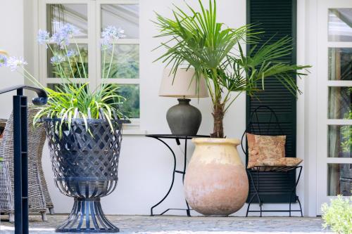 two large vases sitting on a porch with plants at Wein und Landhaus Kallfels in Kröv