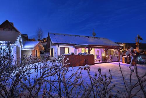 a house covered in snow at night with lights at Rekreační domek Kobylnice Lipno in Lipno nad Vltavou