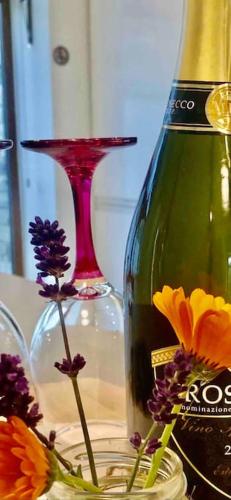 a bottle of wine sitting next to a vase with flowers at Muckruss Lodge Clonakilty An Oasis of Tranquility in Clonakilty