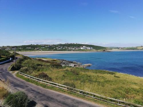 a road leading to a beach next to the water at Muckruss Lodge Clonakilty An Oasis of Tranquility in Clonakilty