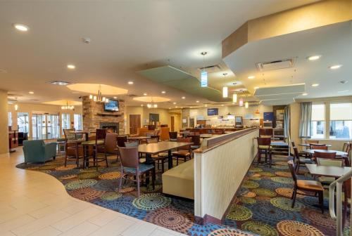 a dining room with tables and chairs in a restaurant at Holiday Inn Express Hotel & Suites Pittsburgh Airport by IHG in Robinson Township