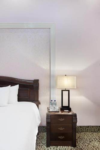a bedroom with a bed and a table with a lamp at Hotel la Perla Leon in León