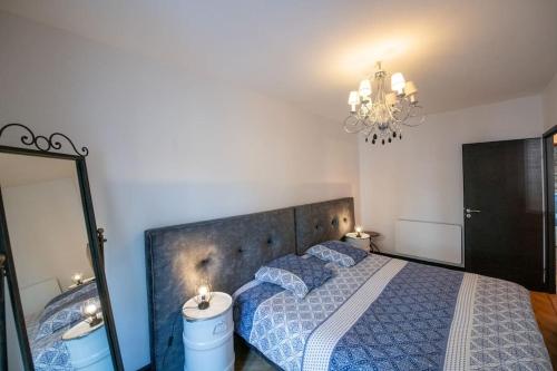 - une chambre avec un lit, un miroir et un lustre dans l'établissement La Suite de Chantilly - Appartement de 80m2 avec Jacuzzi privé !, à Chantilly